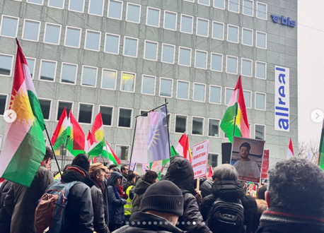 people at rally with Kurdish flags